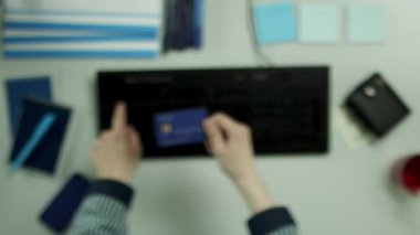 Üstten Görünüm vurdu. Bir genç onun kredi kartı numaraları kontrol ediyor