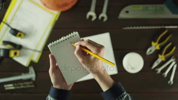 Top down view. Writing in the notepad with coffee — Stock Video