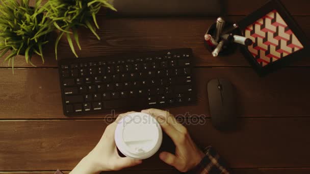 Overhead shot of man with cup of coffee typing on keyboard — Stock Video