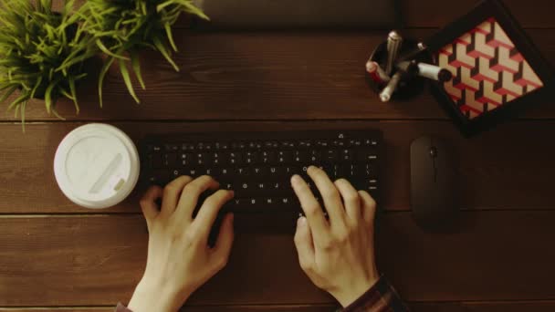 Plan du haut vers le bas de l'homme buvant du café tout en tapant sur le clavier — Video