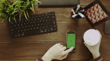 Yukarıdan aşağıya kahve yudumlarken onun smartphone ile yeşil ekran kullanan adam vurdu