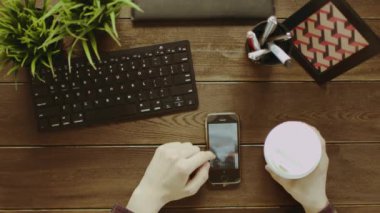 Yukarıdan aşağıya smartphone cep telefonu ile fotoğraf izliyor ve çay içme adam görünümünü