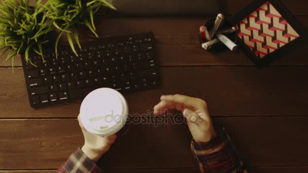 Overhead view of man having video chat and gesticulating while drinking coffee — Stock Video