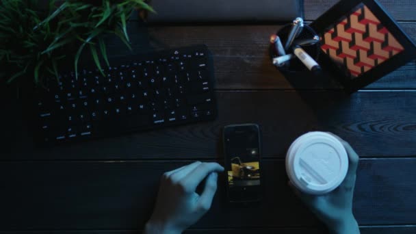 Adam akıllı telefon fotoğrafları izlerken ve çay içme havai görünümü — Stok video