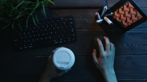 Верхний выстрел человека с помощью компьютерной мыши с чашкой кофе в другой руке — стоковое видео