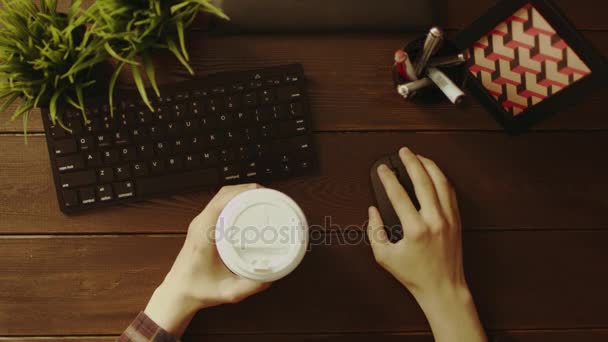 Visão aérea do homem usando o mouse do computador com xícara de café em outra mão — Vídeo de Stock