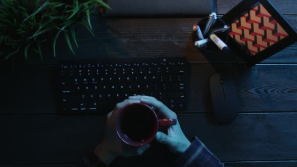 Εναέρια άποψη για τον άνθρωπο που πίνει καφέ ενώ κάθεστε μπροστά από τον υπολογιστή — Αρχείο Βίντεο
