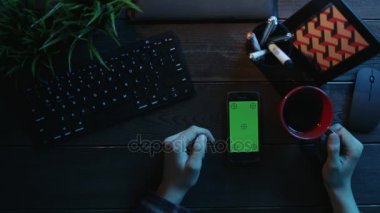 Adam onun smartphone ile yeşil ekran kullanarak ve çay içme genel gider atış