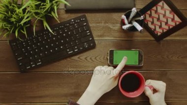 Adam Yeşil perde ile smartphone kullanarak ve kahve içme genel gider atış