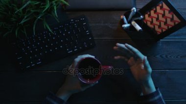 Adamın elinde çay ile bilgisayar önünde gesticulating havai görünümü