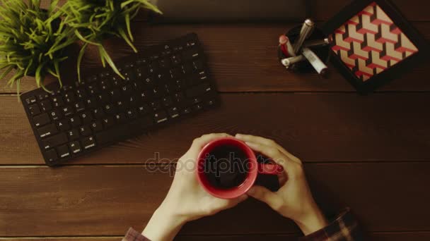 Overhead shot of man gesticulating in front of computer with cup of tea in his hand — Stock Video