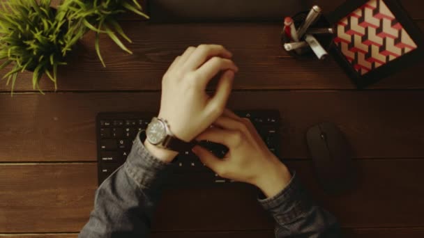 Pohled člověka odkládali své hodinky a psaní na klávesnici — Stock video