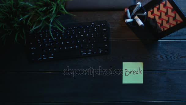 Top down shot of man sticking notes with words "coffee break" on them and putting cup of coffee on table between them — Stock Video