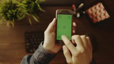 Onun smartphone ile yeşil ekran kullanan adam havai görünümü
