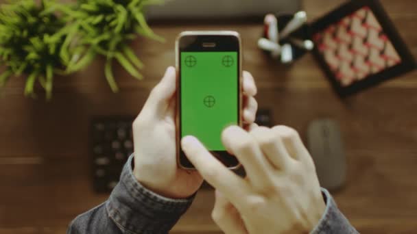 Mann mit Smartphone und grünem Bildschirm fotografiert — Stockvideo