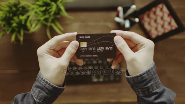 POV shot van man op zoek op zijn credit card en typen op toetsenbord na die — Stockvideo