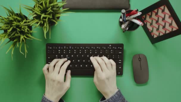 Вид зверху знімок людини, що друкує на клавіатурі з зеленим екраном на фоні — стокове відео