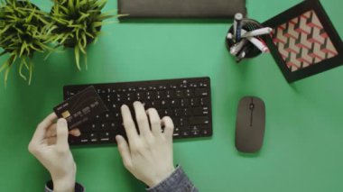 Yukarıdan aşağı atış adamın kredi kartı ve bilgisayar kullanarak bir şey online satın alma