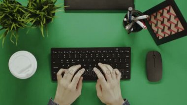 Yukarıdan aşağı atış adam klavyede yazarak ve kahve içme