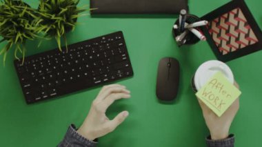 Yukarıdan aşağı atış bir bilgisayarla iletişim fincan kahve wating için çalışan adam