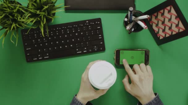 Overhead tiro do homem usando seu smartphone com tela verde durante o coffee break — Vídeo de Stock