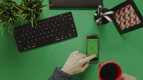 Overhead tiro de homem deslizando tela verde smartphone e beber chá — Vídeo de Stock