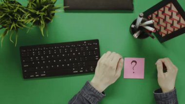 Yukarıdan aşağı atış adamın çalışmaya başlamadan önce masada Not soru işareti bulunan yapıştırma