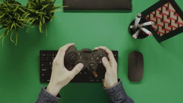 Сверху вниз снимок человека, играющего в компьютер с помощью геймпада — стоковое видео