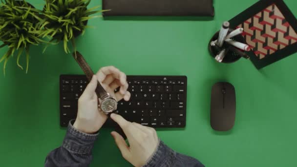 Topp-ned-utsikt over mannen som tar av seg klokka før han skriver på tastatur – stockvideo