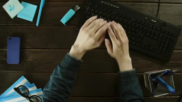 En man flexar sina händer och skriver på tangentbordet på datorn. — Stockvideo
