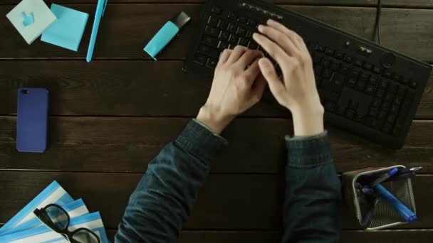 Человек печатает на клавиатуре компьютера на столе и прячет что-то, что печатает, используя подержанную руку. . — стоковое видео
