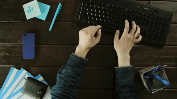 Un hombre escribe en un teclado de computadora en su escritorio . — Vídeo de stock