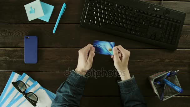 Un hombre escribe en un teclado de computadora en su escritorio . — Vídeo de stock