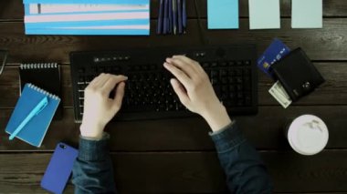 Bir adam türleri, bilgisayar klavyesindeki masasının ve bir şeyler saklıyor bu ikinci el kullanarak yazdırır.