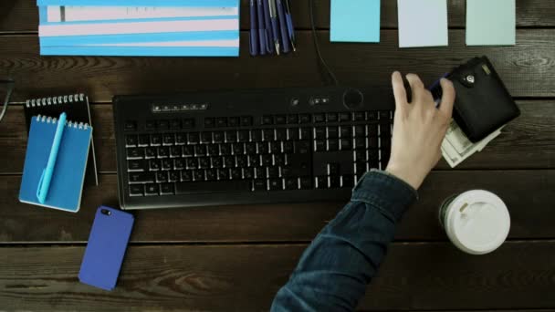 A man seat on a computer keyboard on his desk. — Stock Video