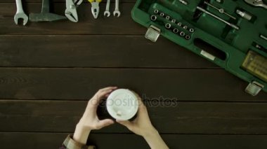 Bir adam oturur bir masa onun yanında bir bavul ve kahve içiyor.
