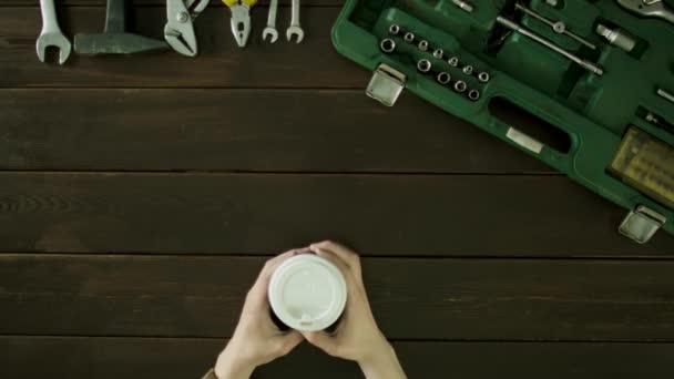 남자에 앉고 그 옆에 테이블 가방 이며 그 커피 음료. — 비디오