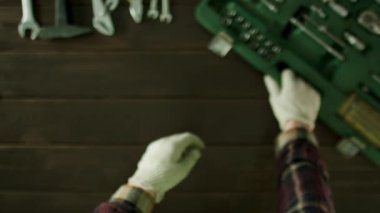 Sonra eller esneme adam araç kutusu yakınındaki bir masada oturur ve kahve içer ve telefonda bir şey izlemek.