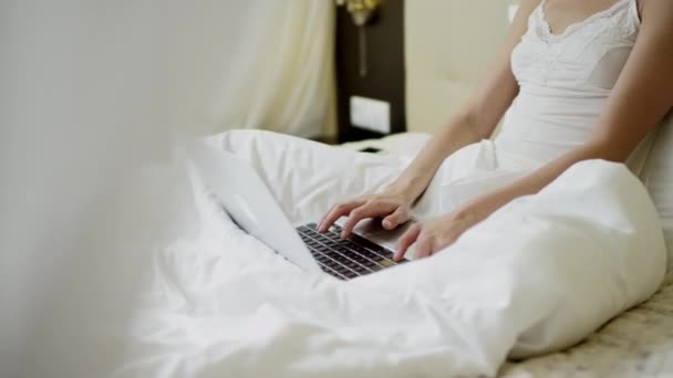 Giovane donna che utilizza il computer portatile a letto — Video Stock