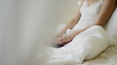 Genç tatlı kadın yatakta onun laptop klavye yazarak içinde pijama giymiş