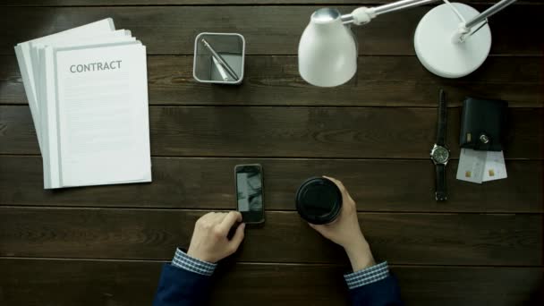 Vista superior.Los hombres están sentados en el teléfono y tomando café . — Vídeos de Stock