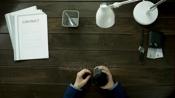 Vue du haut.Les hommes sont assis au téléphone et boivent du café . — Video