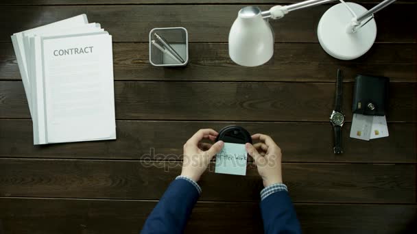 Man glues a sticker on a glass of coffee with text after work. — Stock Video