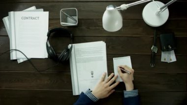 Sözleşmeler ve diyagramları müzik ile bakan bir adam .