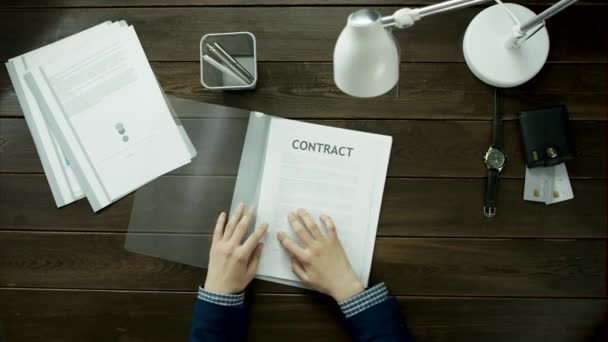 Um homem olha para contratos e diagramas . — Vídeo de Stock