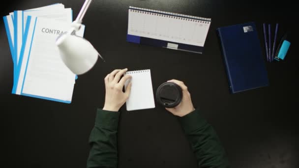 Um homem está sentado em uma mesa de escritório e usando um telefone . — Vídeo de Stock