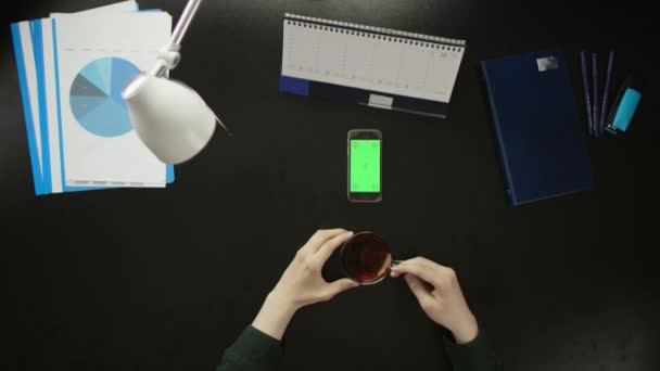 Мужчина сидит за рабочим столом и пользуется телефоном . — стоковое видео