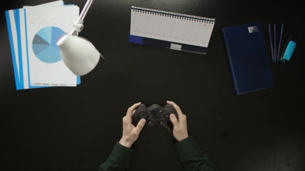 Um homem está sentado em uma mesa de escritório e usando um telefone . — Vídeo de Stock