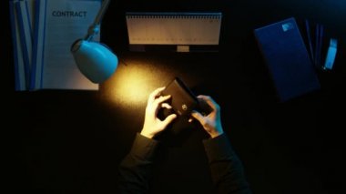 Bir adam bir ofis masa başında oturan ve bir telefon kullanma.