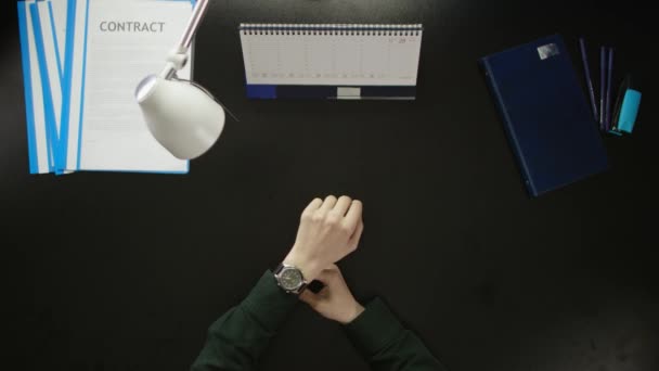 Um homem está sentado em uma mesa de escritório e usando um telefone . — Vídeo de Stock